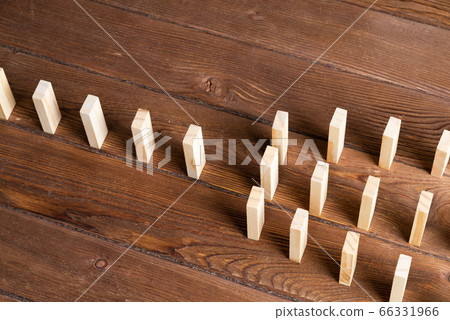 Rows of dominoes standing on wooden table 66331966
