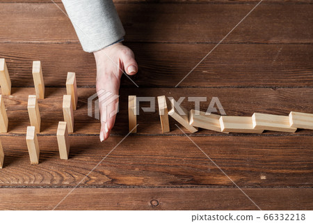 Business woman hand block domino effect 66332218