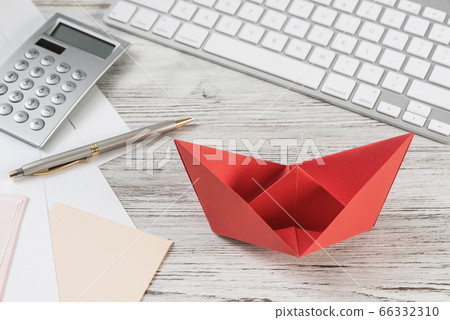 Businessman workspace at desk with red paper ship Businessman workspace at desk with red paper ship 66332310