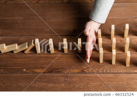 Business woman interrupting domino effect Business woman interrupting domino effect 66332524