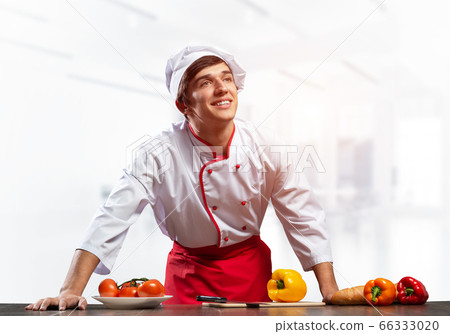 Young smiling chef standing near cooking table 66333020