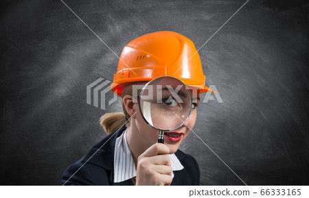 Building inspector looking through magnifier Building inspector looking through magnifier 66333165
