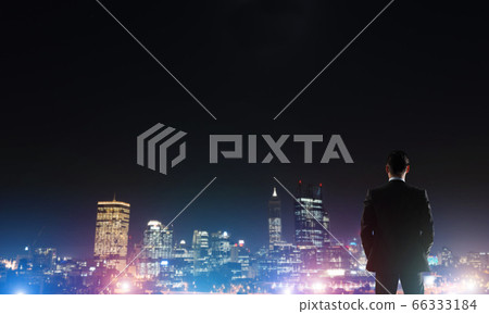 Businessman viewing night glowing city 66333184