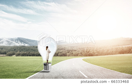 Businesswoman inside light bulb Businesswoman inside light bulb 66333468