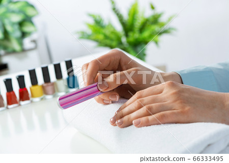 Woman using nail file and create nails shape 66333495