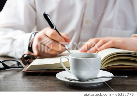 Man making notes with pen in notebook 66333776
