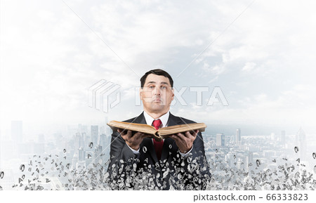 Senior businessman holding old open book Senior businessman holding old open book 66333823