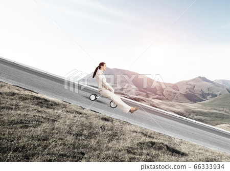 Beautiful happy woman riding downhill 66333934