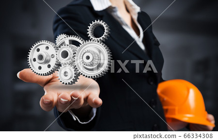Businesswoman holds in palm gears mechanism 66334308