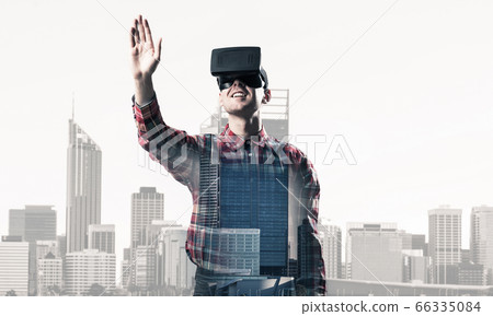 Guy wearing checked shirt and virtual mask stretching hand to touch something Guy wearing checked shirt and virtual mask stretching hand to touch something 66335084