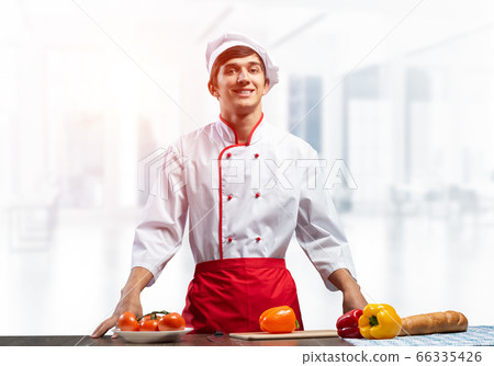 Young smiling chef standing near cooking table 66335426