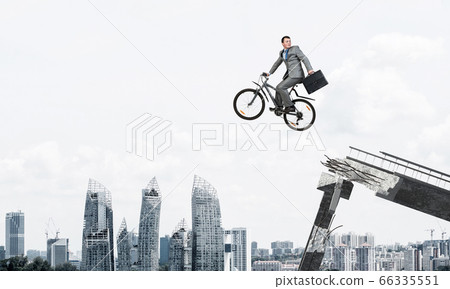 Man on bike jumping from broken bridge Man on bike jumping from broken bridge 66335551