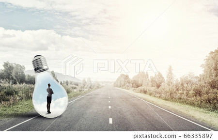 Businesswoman inside light bulb Businesswoman inside light bulb 66335897