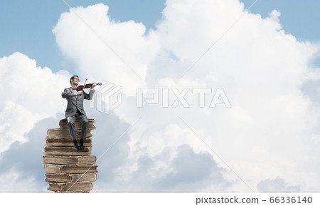 Handsome Violinist In Blue Day Sky On Pile Of Stock Photo