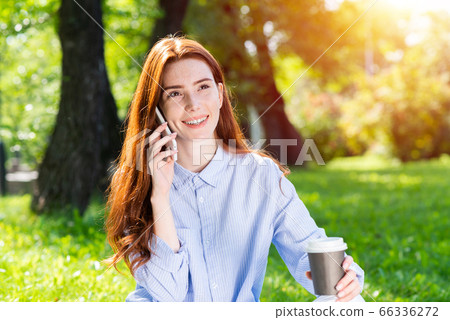 Young redhead woman talking on smartphone Young redhead woman talking on smartphone 66336272