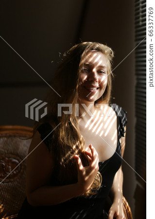 Portrait of young caucasian woman sitting in chair, striped shadows. Portrait of young caucasian woman sitting in chair, striped shadows. 66337769