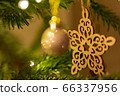 A wooden star shaped Christmas Tree Decoration hanging from a tree 66337956