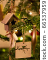 A wooden house shaped Christmas Tree Decoration hanging from a tree 66337959