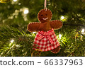 A fabric gingerbread man woman bear shaped Christmas Tree Decoration hanging from a tree 66337963