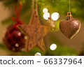 A glittery heart  shaped Christmas Tree Decoration hanging from a tree 66337964