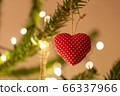 A fabric heart shaped Christmas Tree Decoration hanging from a tree 66337966