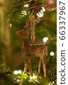 A wooden reindeer shaped Christmas Tree Decoration hanging from a tree 66337967