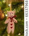 A white wooden bear shaped Christmas Tree Decoration hanging from a tree 66337968