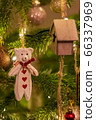 A white wooden bear shaped Christmas Tree Decoration hanging from a tree 66337969