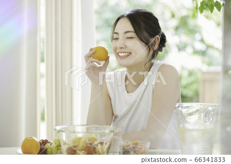A young woman eating a salad in the living room [Beauty] 66341833