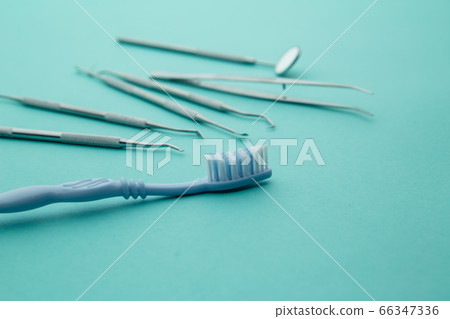 Dentist tools close-up. Professional steel dental instruments with a mirror on light blue background. Dental health and teethcare concept Dentist tools close-up. Professional steel dental instruments with a mirror on light blue background. Dental health and teethcare concept 66347336