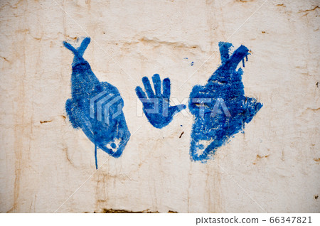 MATMATA, TUNISIA - February 03, 2009: Picture of a hand and fish symbol on traditional berber house wall in the sahara 66347821