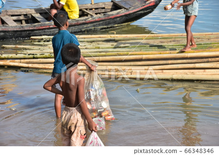 Cox's Bazar in Bangladesh A boy who collects garbage on the coast for his life A lot of bamboo floating in the sea 66348346