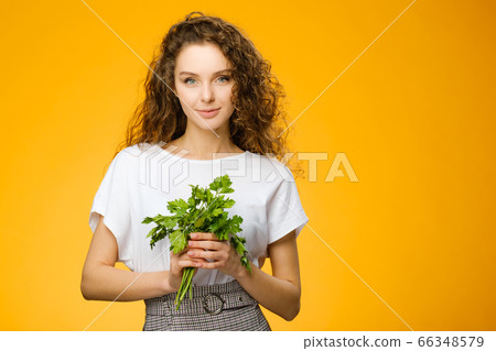 Pretty girl with curly hair holding parsley 66348579