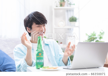Young men attending an online drinking party with a laptop 66350071