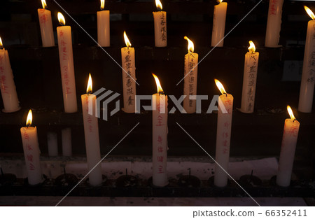 Pray with a candle at the temple 66352411