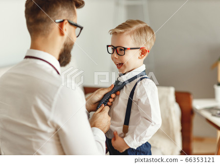 Father dressing son at home. Father dressing son at home. 66353121