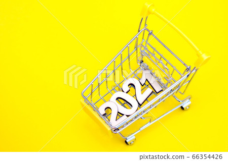 The numbers 2021 in a supermarket toy cart on a yellow background. The numbers 2021 in a supermarket toy cart on a yellow background. 66354426