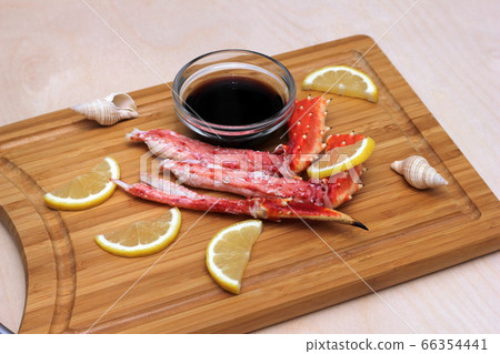 Crab meat and lemon on a wooden chopping Board  next to soy sauce in a clear glass bowl. 66354441