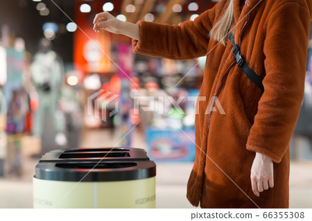 Woman throws object in trash can. Template with empty space Woman throws object in trash can. Template with empty space 66355308