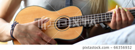 Female hands holding ukulele guitar learning how to play Female hands holding ukulele guitar learning how to play 66356932
