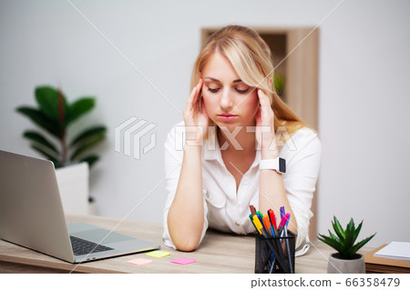 Tired young businesswoman exhausted at workplace in her office 66358479