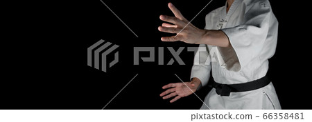 A person practicing aikido on a black background. A person practicing aikido on a black background. 66358481