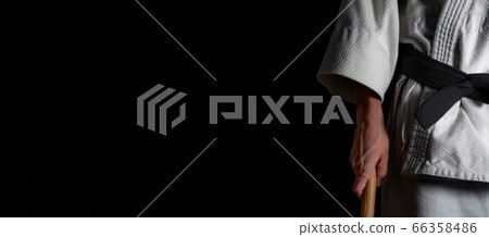 A person practicing aikido on a black background. 66358486