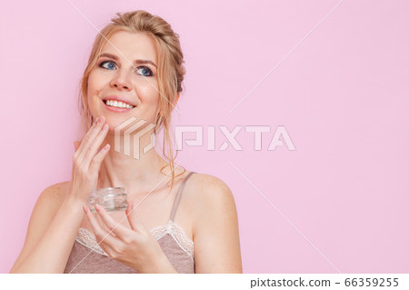 Cute young blonde girl takes care of the skin, applies face cream. A woman takes care of her appearance and health. Cute young blonde girl takes care of the skin, applies face cream. A woman takes care of her appearance and health. 66359255