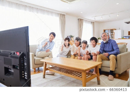 坐在沙發上看電視的3代家庭客廳用餐 66360413