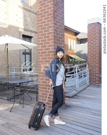 A woman walking with a travel bag A woman walking with a travel bag 66362041