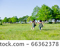 Children running on a cloudless blue sky and fresh green grass 66362378