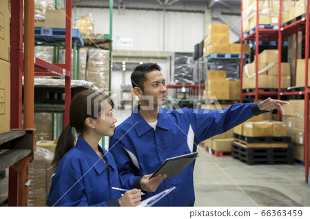 Workers and men who manage products in a distribution warehouse Workers and men who manage products in a distribution warehouse 66363459