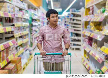 asian man with shopping cart in supermarket 66364801