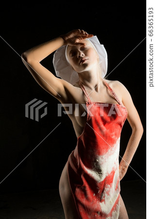 Sensual female baker in apron wiping forehead 66365193